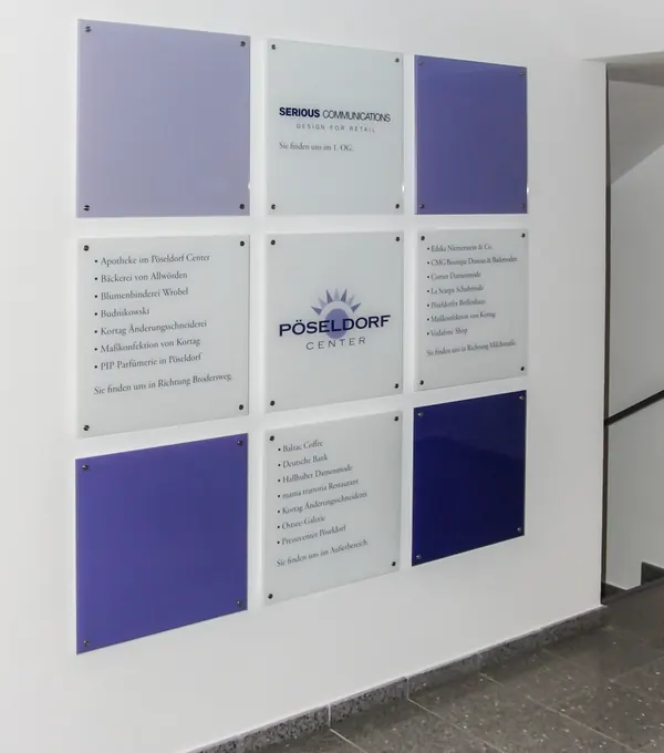 Schilder in Gewebeobjekten als Wegweiser für die Besucher. Schilderbefestigung aus Edelstahl halten diese Glasscheiben an der Wand