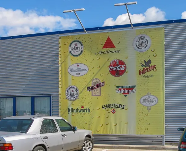 Digital bedruckte Planen als Werbefläche für eine Getränkemarkt. Angestrahlt mit LED-Strahlern