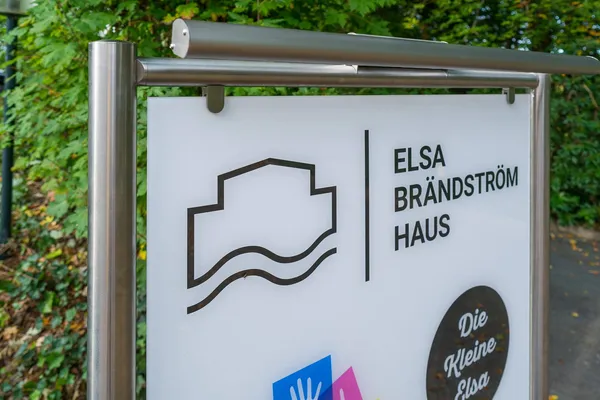 Das Foto zeigt ein Standschild gefertigt aus Edelstahlrohren und einem Werbeschild aus ESG-Glas. Beleuchtet durch eine LED Lichteinheit.