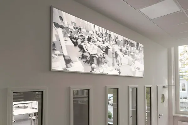Das Foto zeigt ein LED Flächenlicht in einer Hamburger Agentur. Der Bilderdruck zeigt eine Büroscene aus den 60er Jahren.