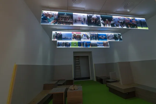 Das Foto zeigt einen LED Lichtfluter von der Decke abgehängt. Auf den leuchtenden Acrylglasscheiben wurden Bilder auf selbstklebender Folie verklebt.
