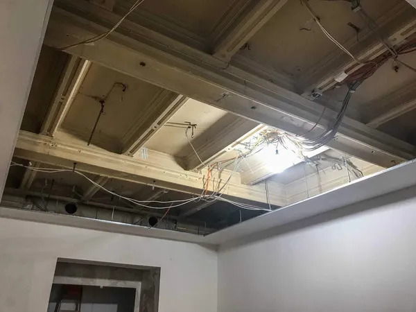 Das Foto zeigt einen LED Lichtfluter von der Decke abgehängt. Auf den leuchtenden Acrylglasscheiben wurden Bilder auf selbstklebender Folie verklebt.