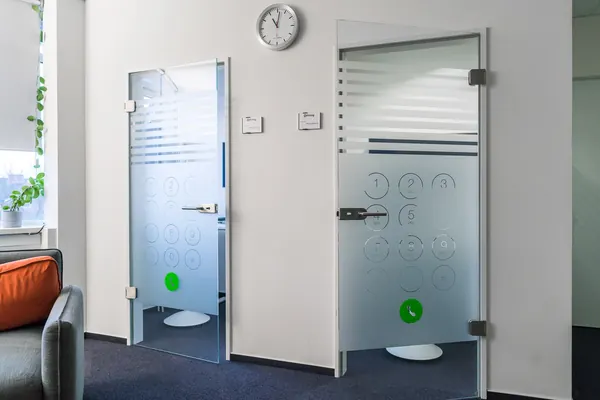 Das Foto zeigt 2 Bürotüren die mit Glasdekorfolien beklebt wurden. Aus der Milchglasfolie ist ein Telefon Tastenfeld ausgelottet.