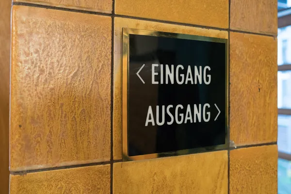 Das Foto zeigt eine hochwertige Beschilderung in einem Hamburger Ärztehaus. Edelstahl polygrat gold spiegelnd veredelt in Verbindung mit schwarzem un weissem Plexiglas.