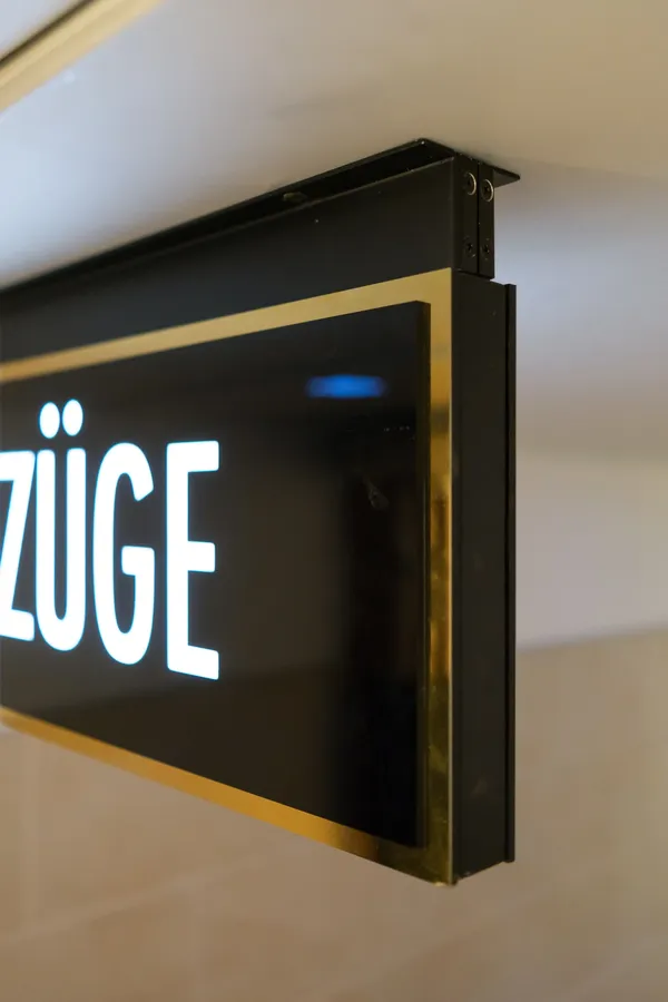 Das Foto zeigt eine hochwertige Beschilderung in einem Hamburger Ärztehaus. Edelstahl polygrat gold spiegelnd veredelt in Verbindung mit schwarzem un weissem Plexiglas.