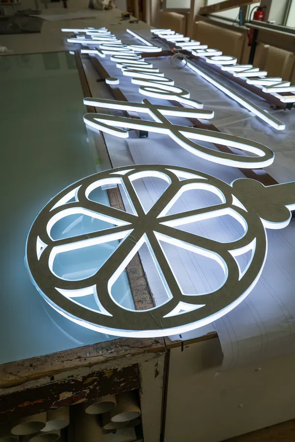 3D Buchstaben aus LED Vollplexi Buchstaben mit gold gebürstetem V2A belegt. Eine Aussenwerbung für Heimatglück Immobilien in Lübeck.