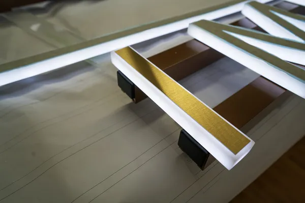 3D Buchstaben aus LED Vollplexi Buchstaben mit gold gebürstetem V2A belegt. Eine Aussenwerbung für Heimatglück Immobilien in Lübeck.