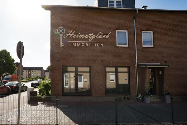 3D Buchstaben aus LED Vollplexi Buchstaben mit gold gebürstetem V2A belegt. Eine Aussenwerbung für Heimatglück Immobilien in Lübeck.